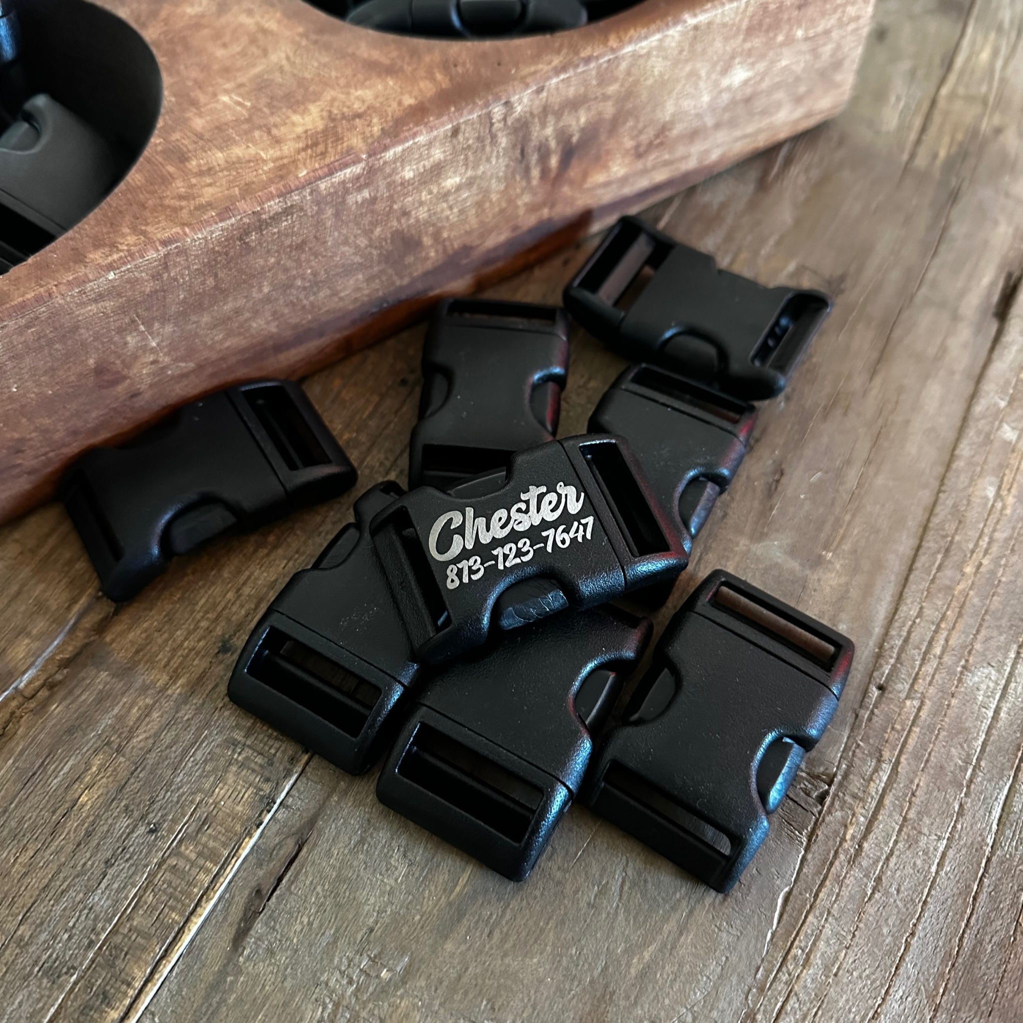 Close-up of laser engraved black acetyl buckle with pet ID text
